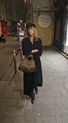 Woman in black walks Paris street early morning