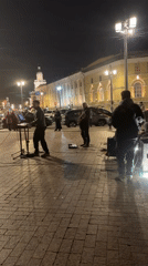 Band performs nighttime street concert near monument in Saint Petersburg