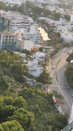 Aerial sweep of Nha Trang where city meets forested mountains
