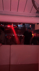 Behind the barrier at a Jesolo event, red lights glowing