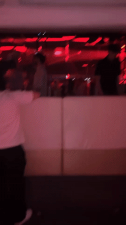 Behind the barrier at a Jesolo event, red lights glowing