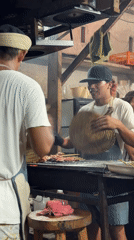 Street vendors grill meat skewers in General Luna