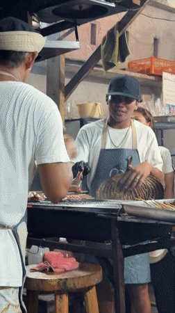 Street vendors grill meat skewers in General Luna