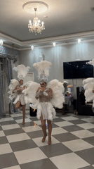 Three costumed dancers perform in feathered outfits in Dzerzhinsk