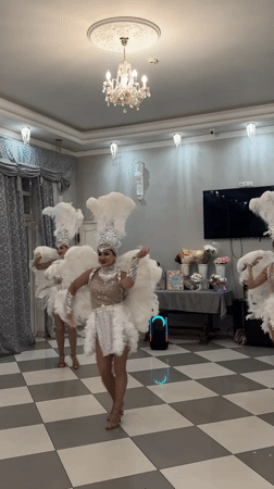 Three costumed dancers perform in feathered outfits in Dzerzhinsk