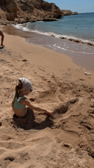 Child plays buried in sand on Sharm El Sheikh beach
