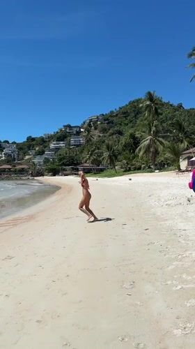 Busy Ko Samui beach with swimmers and jet skis on calm water