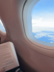 Passenger reads book during flight over Thailand