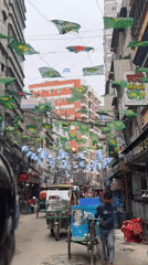Dense street traffic and a rope-laden cart in Dhaka