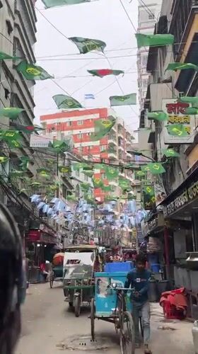 Dense street traffic and a rope-laden cart in Dhaka