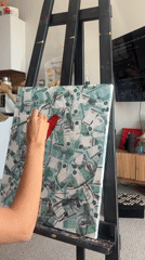 Artist paints red shapes on ruble-covered canvas in Krasnoyarsk