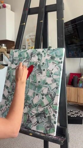 Artist paints red shapes on ruble-covered canvas in Krasnoyarsk