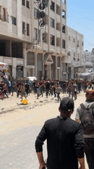 Large crowd moves through damaged Gaza streets