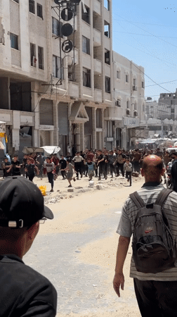 Large crowd moves through damaged Gaza streets