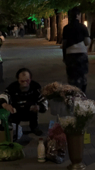 Evening street life captured on Krasnodar walkway with flower vendor