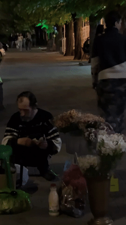 Evening street life captured on Krasnodar walkway with flower vendor
