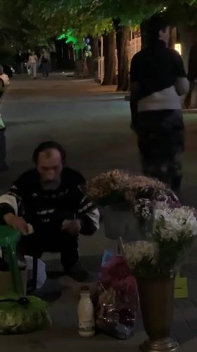 Evening street life captured on Krasnodar walkway with flower vendor