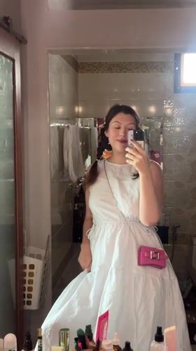 Mirror selfie with pink purse in Thai bathroom