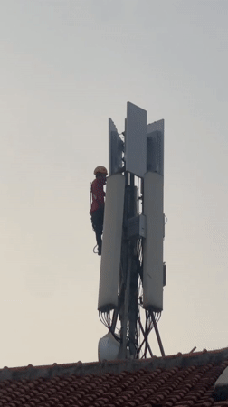 Telecom worker maintains cell tower in North Jakarta