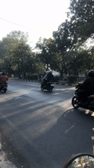Motorcycle-heavy traffic flows through Gelam, Indonesia at golden hour