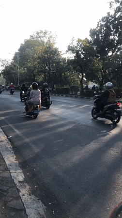 Motorcycle-heavy traffic flows through Gelam, Indonesia at golden hour