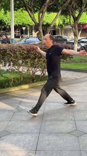 Man practices Tai Chi in waterfront park, Jiangjin China