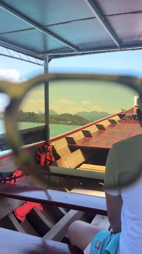 Tourist films longtail boat cruise on Thai lake
