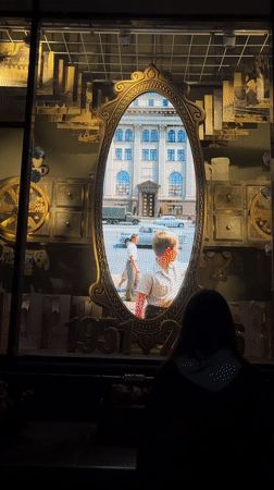 Person views vintage shop display with video mirror in Minsk