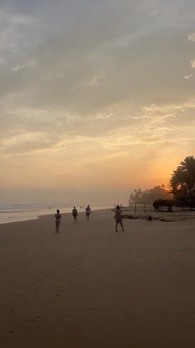 Surfers and beachgoers enjoy sunset at Kathaluwa Beach, Sri Lanka