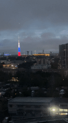City tower displays red, white, blue illumination at dusk