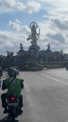 Motorcycle rider navigates busy Denpasar roundabout during morning commute