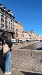 Woman points toward canal from bridge in Saint Petersburg