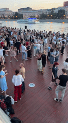 Couples dance riverside on a Moscow deck at golden hour