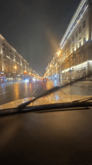 Car drives through rainy Moscow streets at night