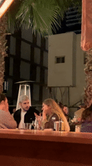 Three people gather at outdoor table in Tel Aviv