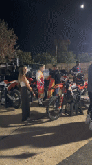 Nighttime motocross event with smoke, ramps, and crowds in Andalusia