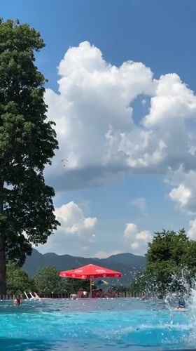 Summer day at Oberammergau's outdoor pool, Alps in the background
