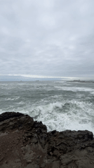 Overcast evening captured along Arica's rocky coastline with ships offshore