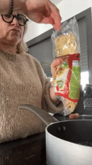 Woman holds noodle package in Chambœuf kitchen