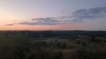 Dusk gradient sky stretches over Podilsk's open landscape.