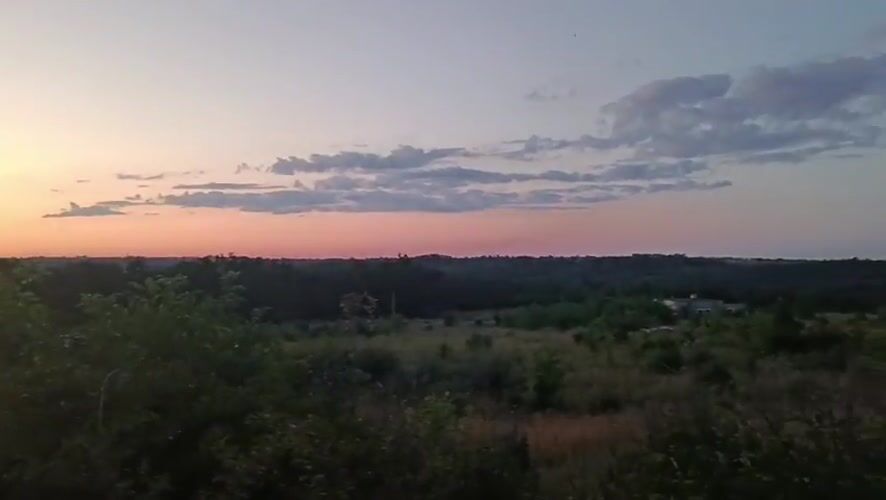 Dusk gradient sky stretches over Podilsk's open landscape.