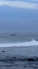 Green boat with passengers spotted near rocky coast
