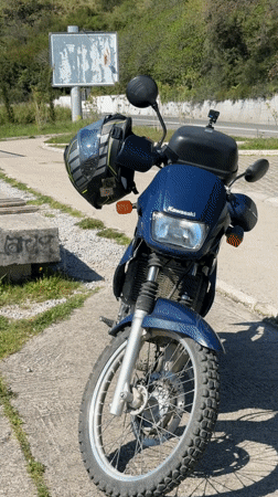 Blue Kawasaki motorcycle parked near benches in Prijevor, Montenegro