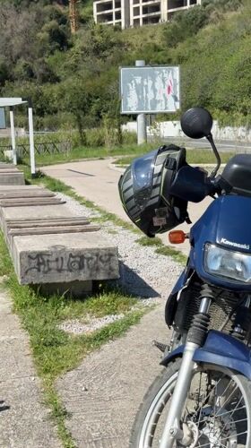 Blue Kawasaki motorcycle parked near benches in Prijevor, Montenegro
