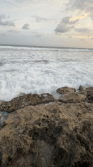 Person observes waves from rocky shoreline in Habaraduwa
