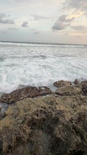 Person observes waves from rocky shoreline in Habaraduwa