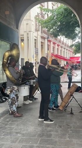 Brass band performs under covered walkway in Paris