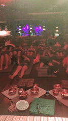 People rest on mats in dimly lit room in Blahbatuh