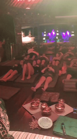 People rest on mats in dimly lit room in Blahbatuh