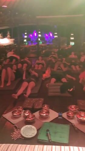 People rest on mats in dimly lit room in Blahbatuh